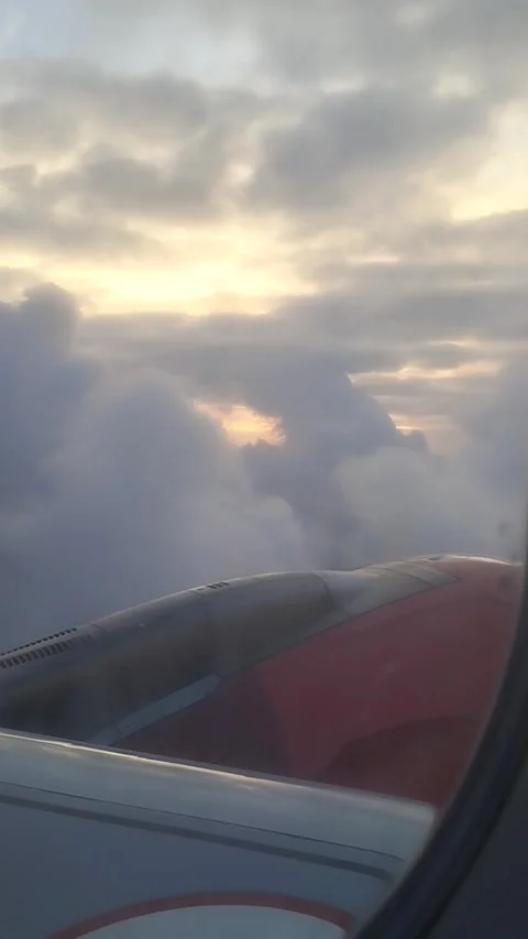Sunset behind clouds from a Plane Window Over the Ocean Video stock 281835780