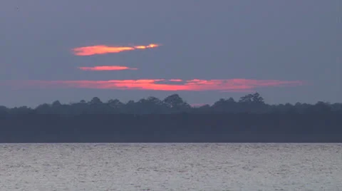 Sunset behind clouds on the waterway, 100% Stock Footage 24453284