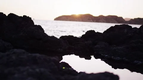 Sunset behind Coastal Headland Reflected in a Rocky Tide Pool, Static Shot Stock Footage 340627442