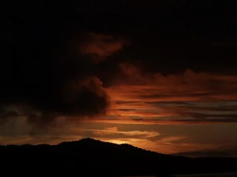 Sunset behind dark mountains Stock Photos
