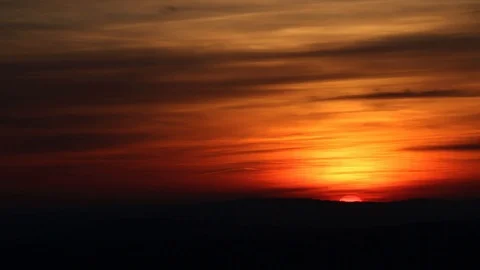 Sunset behind far hills with sun visible between clouds Stock Footage 106354963