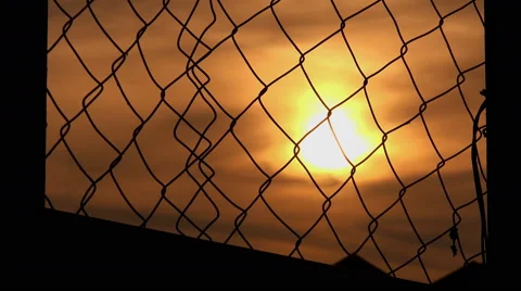 Sunset behind the fence of a prison 스톡 동영상 62873532