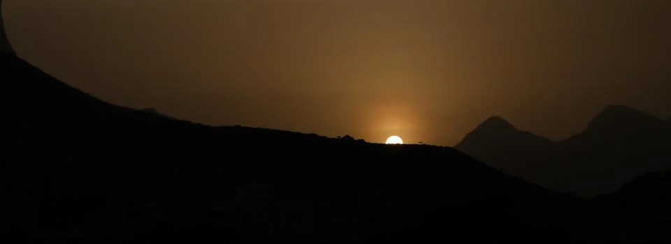 Sunset behind the high mountains Stock Photos