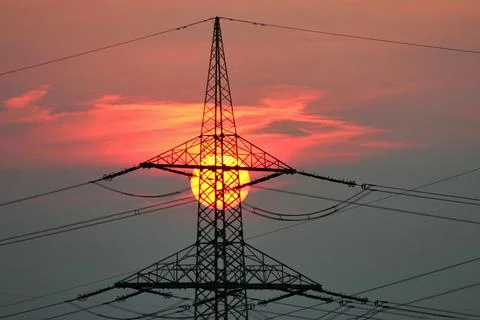 Sunset behind a high voltage pylon solar energy climate neutral change climatic Foto stock