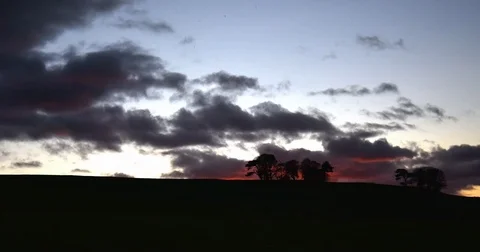Sunset behind hill with isolated trees british countryside timelapse 動画素材 82657435