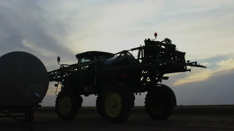 Sunset behind huge tractor in Texas cotton field, 4K. Stock Footage 140102002