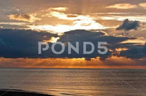 Sunset behind massive clouds Stock Photos