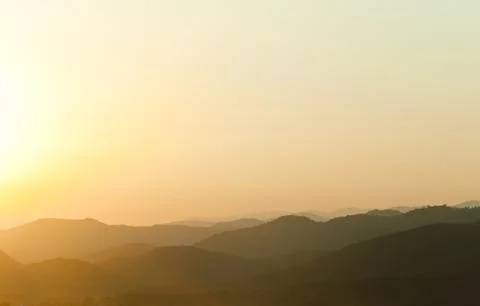 Sunset behind mountains Stock Photos