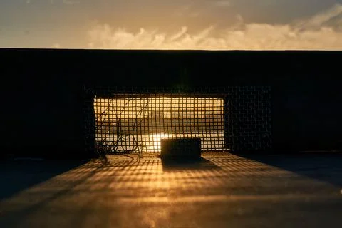 Sunset Behind Mysterious Object with Mesh, Shadow On Ground Stock-Fotos