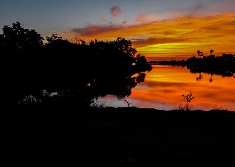 Sunset behind the pond Stock Photos