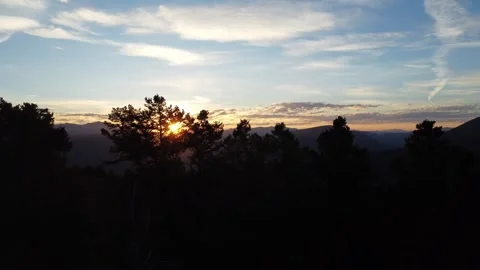 Sunset behind tree branches in mountains Stock Footage 312042447