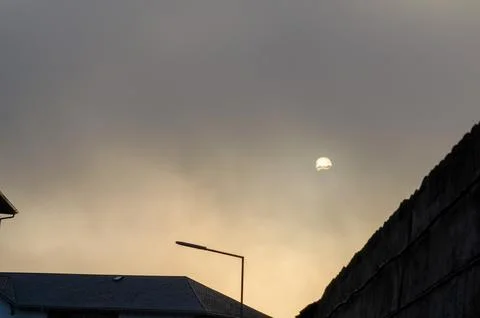 Sunset Behind Urban Buildings with Dramatic Sky and Street Lamp Silhouette Stock Photos