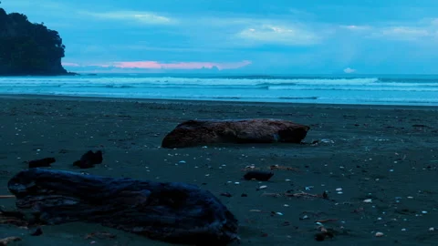 Sunset Beyond Clouds on a Black Sandy Beach 스톡 동영상 250140407