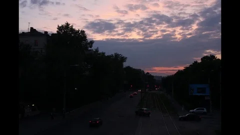 Sunset in a big city, traffic, trams run, light turns on Stock-Footage 74264698
