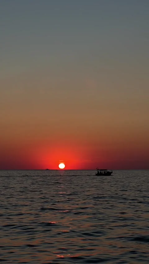 Sunset boat ride on sea waves, silhouette of boat against horizon Stock Footage 304879340