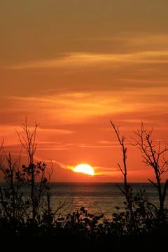Sunset is bounded by a mirage of sky and sea, there are silhouettes in the .. Stock Photos