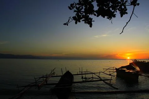 Sunset is bounded by a mirage of sky and sea, there are silhouettes in the .. Stock Photos