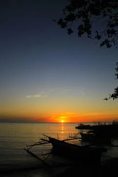 Sunset is bounded by a mirage of sky and sea, there are silhouettes in the .. Stock Photos