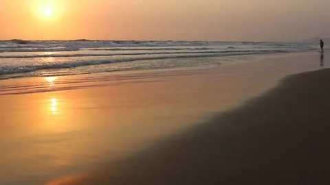 At sunset, the boy runs along the beach.  Stock Footage 107782892