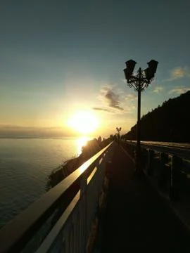 Sunset on the bridge, a lantern against the sun, a Golden hour over the sea, Stock Photos