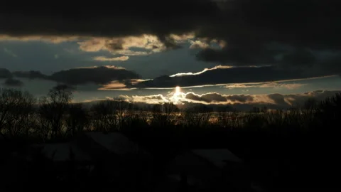 Sunset with bright orb of the sun silhouetting leafless winter trees Stock Footage 152851894