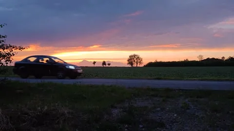 The sunset is bright red and the car Vídeo Stock 337127720