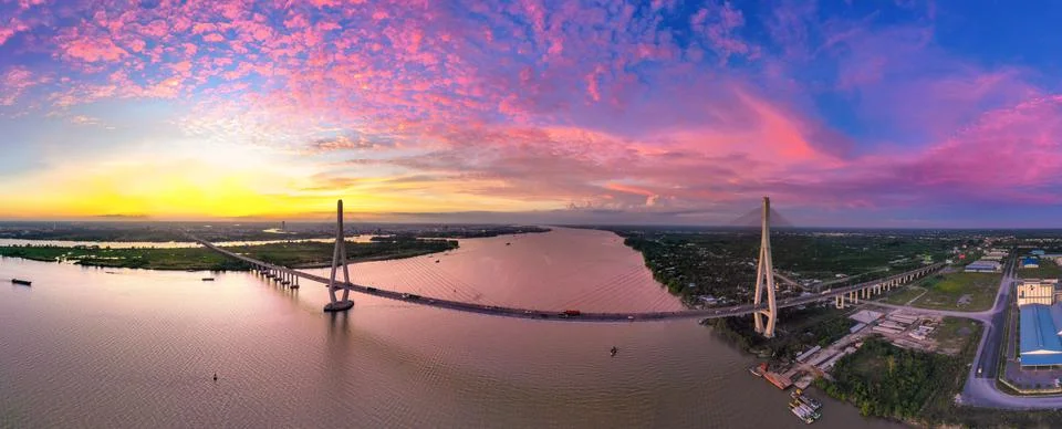 The sunset is brilliant on the Hau River with Can Tho bridge crossing it. 2 Stock Photos
