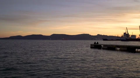 Sunset in a calm harbor with a pier. - 4K Vídeo Stock 335550739