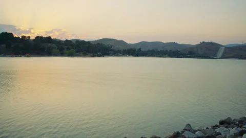 Sunset at the calm scenic lake, surrounded by mountains and hills. Quiet summer  Vídeos de archivo 285809420