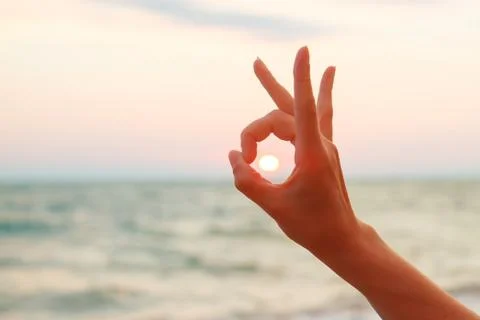 Sunset captured by hand under the OK sign Stock-Fotos