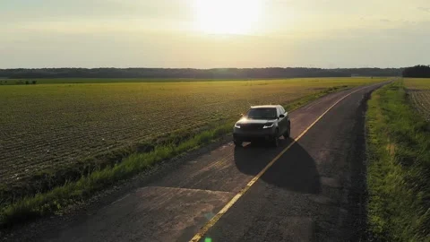 Sunset car driving on the road in the field Stock Footage 201548039
