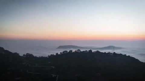 Sunset casting golden light over rolling hills CLOUDS Stock Footage 302265270