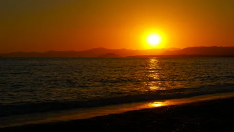 Sunset casting a warm glow over the ocean horizon Stock Footage 305396574