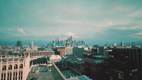 Sunset casts glow over urban skyline featuring buildings and clouds Stock Footage 326296141