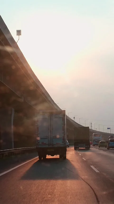 Sunset casts golden glow over busy highway Stock Footage 337834435