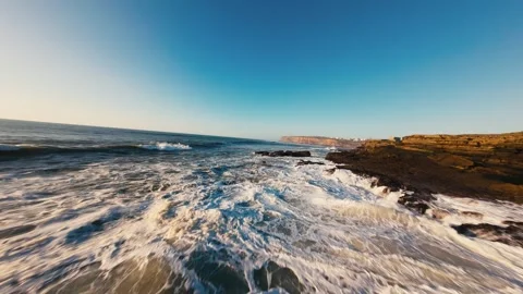 Sunset casts golden glow over rolling ocean waves Stock Footage 339788008