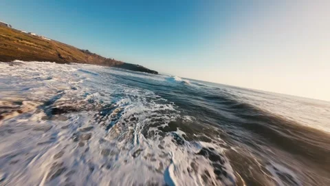 Sunset casts golden glow over rolling ocean waves Stock Footage 339788018