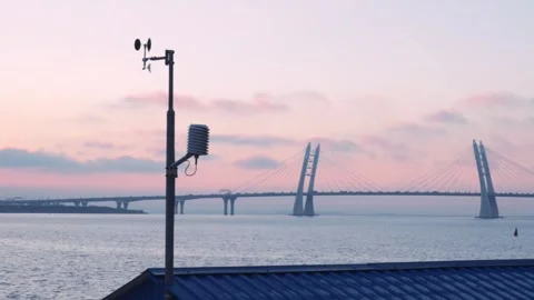 Sunset casts warm glow on weather station, a cable-stayed bridge spanning serene Stock Footage 270796476