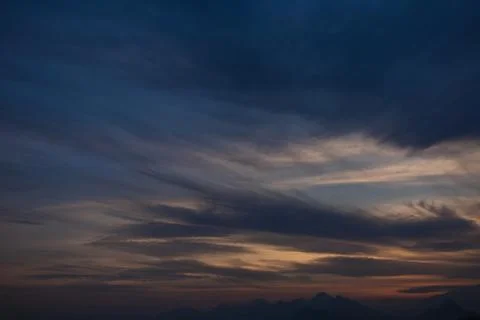 Sunset charming sky background with soft calm white clouds and evening sunlight Stock Photos