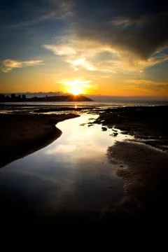 Sunset on a city beach Stock Photos