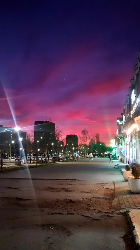 Sunset city Multi-story high-rise buildings illuminated windows road moving cars Stock Footage 328206540