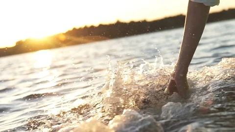At sunset, close-up the hand of a girl moving through the water Stock Footage 101518699