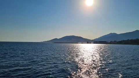 Sunset on cloudless sky and calm sea surface in the background Stock Photos