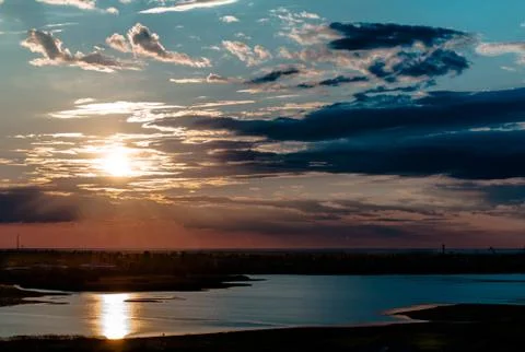 Sunset in the clouds above the Bay on a background of the blue sky Stock Photos