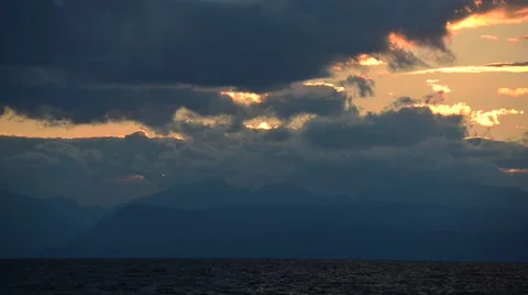 Sunset in the clouds above the water. Stockbeeldmateriaal 44229322