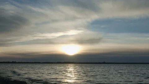 Sunset with clouds and blue sky over cold lake or river Video stock 96019150