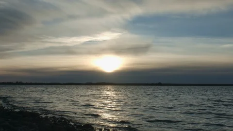 Sunset with clouds and blue sky over cold lake or river Stock Footage 96019170