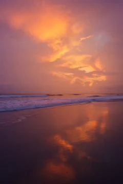 Sunset clouds and waves on empty beach Foto stock
