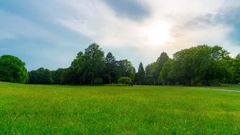 Sunset clouds drifting above urban park during smooth slider timelapse. Golden Stock Footage 337414935