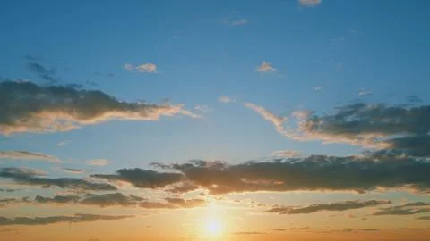 Sunset with clouds in motion. Summer sky at sunset with clouds. Timelapse. Stock Photos
